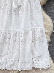White eyelet tiered maxi skirt with tassel detail and ruffled hem.