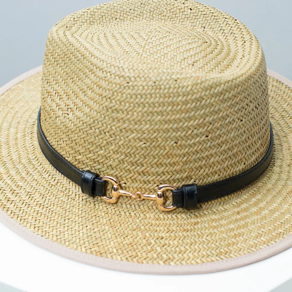 Woven straw fedora hat with black decorative band and gold buckle detail.