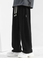 Men's black casual drawstring sweatpants with a loose fit and side pocket detail.