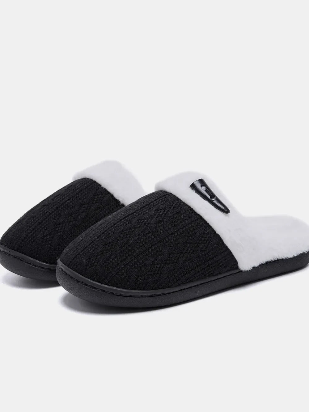 Black cable knit shearling house slippers with white trim and a black accent detail.