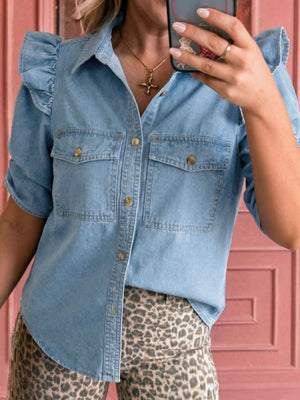Light wash denim button-down shirt with ruffled short sleeves and chest pockets.