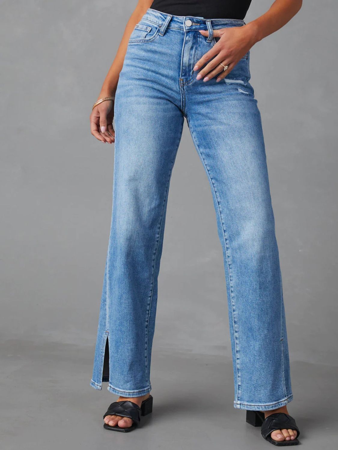 Medium wash split hem flare jeans with a button fly and distressed detail.