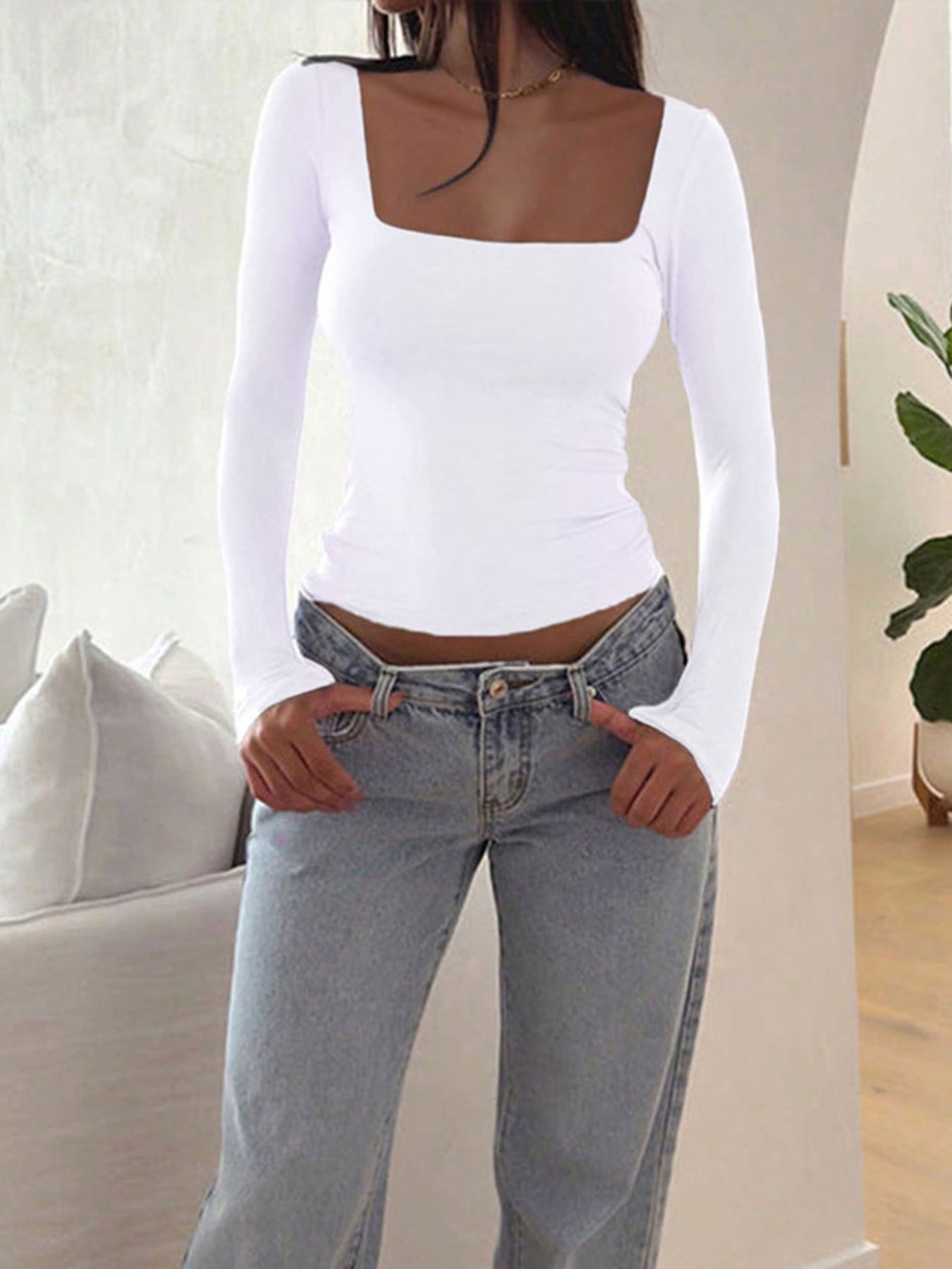 White long sleeve slim fit t-shirt with a square neckline, styled with jeans.