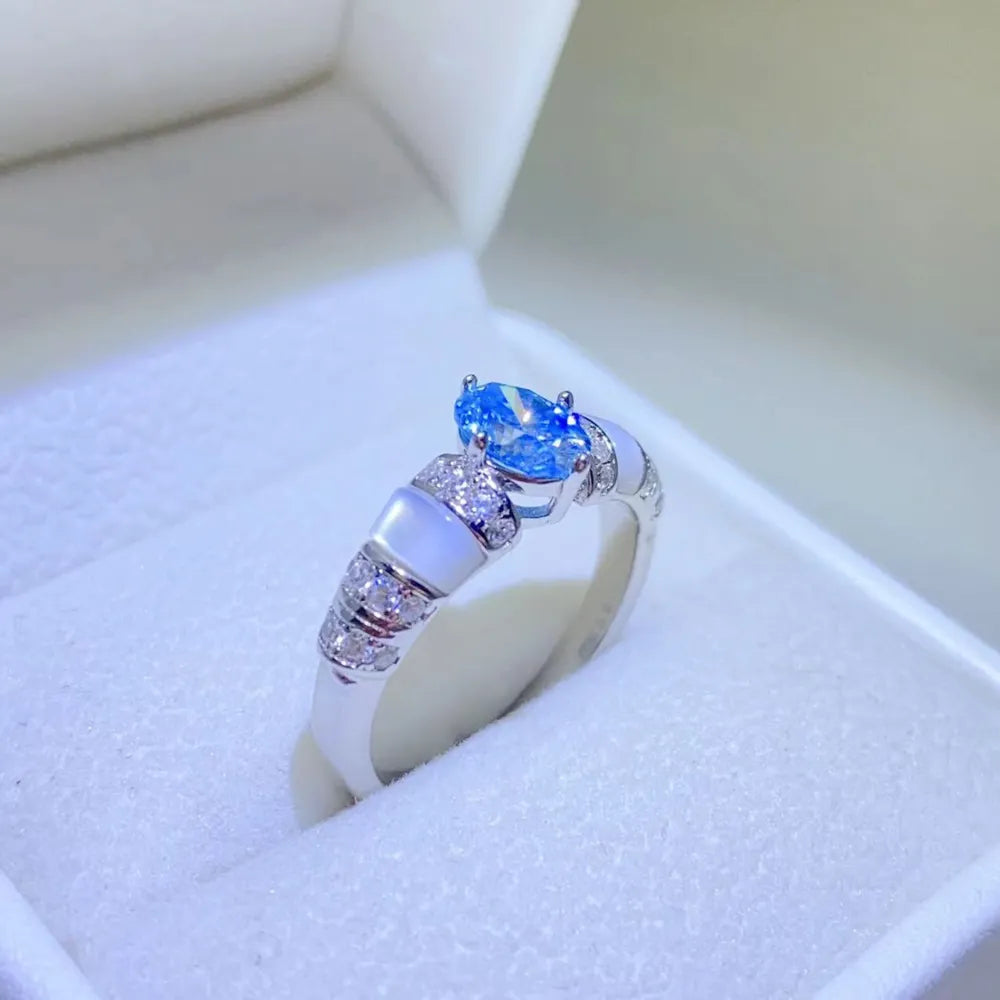 Silver ring with blue oval moissanite and mother-of-pearl accents