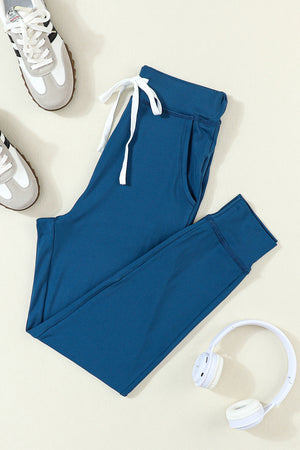 Slim-fit dark blue drawstring joggers with pockets and cuffed ankles.