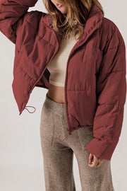 Cropped brick red puffer jacket with hood, zip front, and cinched hem.