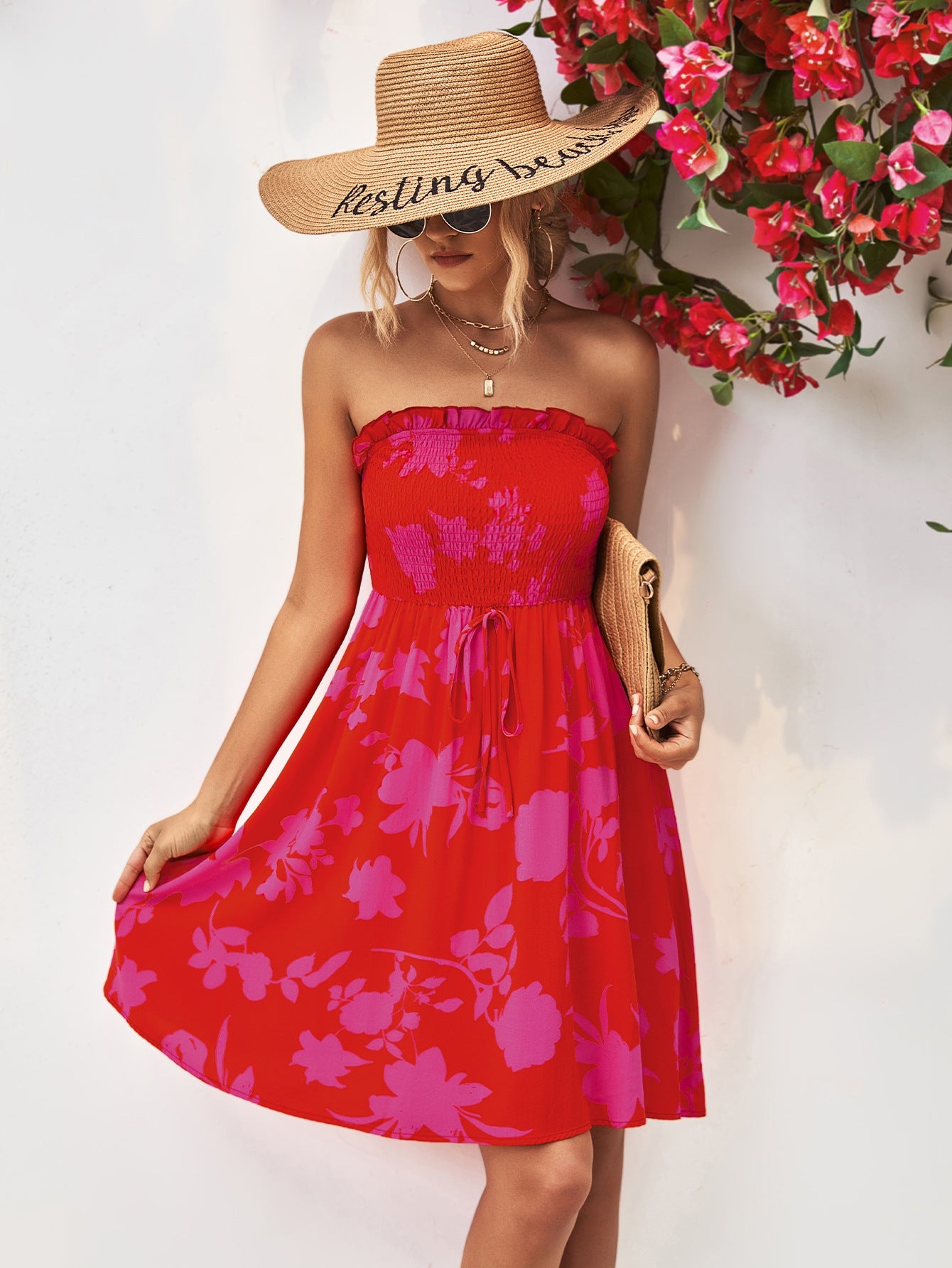 Red smocked bandeau mini dress with pink floral print and drawstring waist.