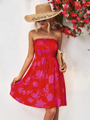 Red smocked bandeau mini dress with pink floral print and drawstring waist.