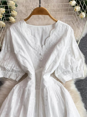 White lace-embellished A-line midi dress with V-neck and button front.