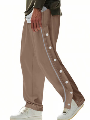 Men's khaki track pants with snap buttons down the side and reflective stripe detail.