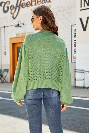 Green bubble sleeve cropped cardigan with textured detail and open knit pattern.