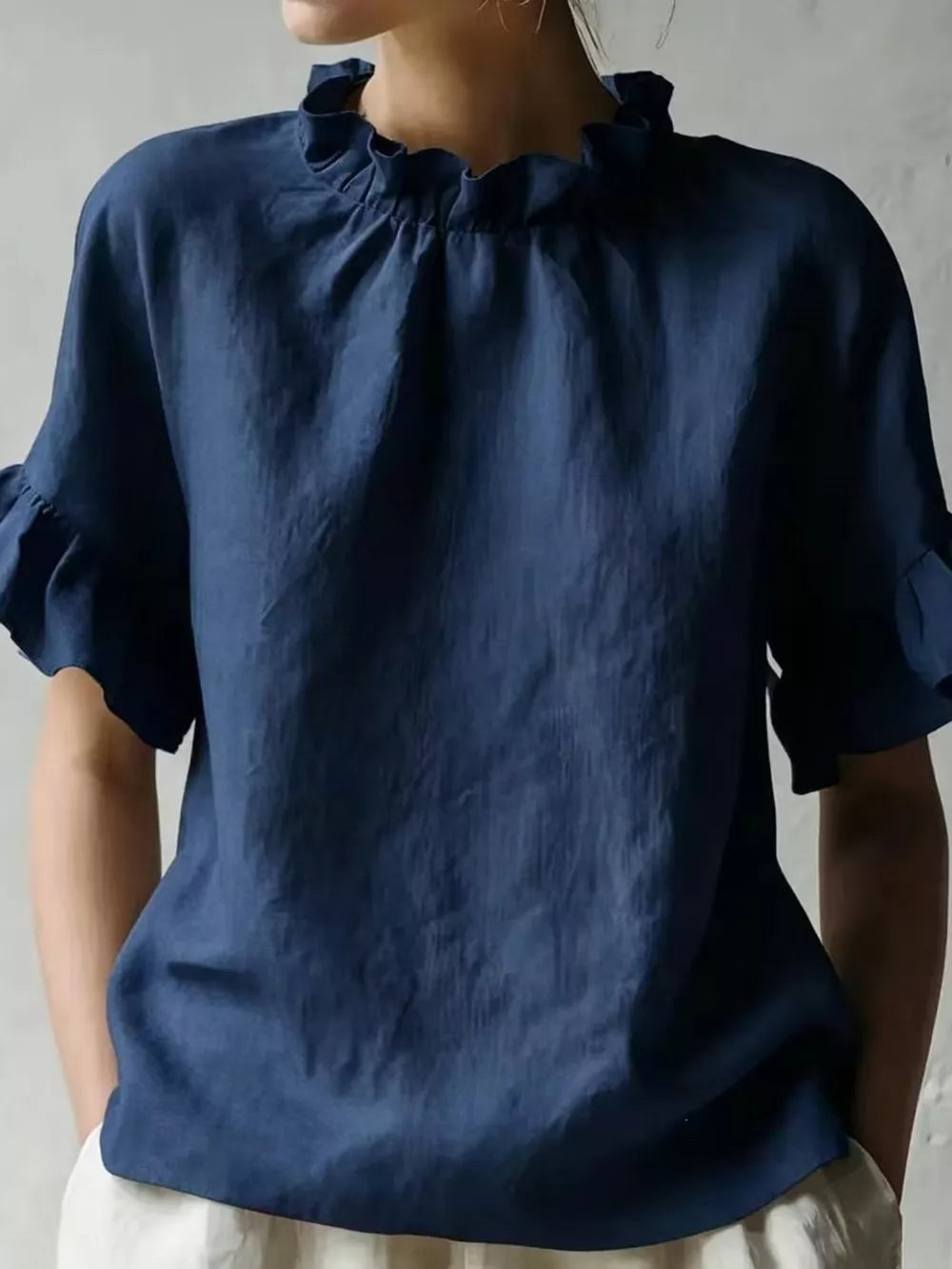 Dark blue half-sleeve shirt with ruffled neckline and sleeve cuffs.