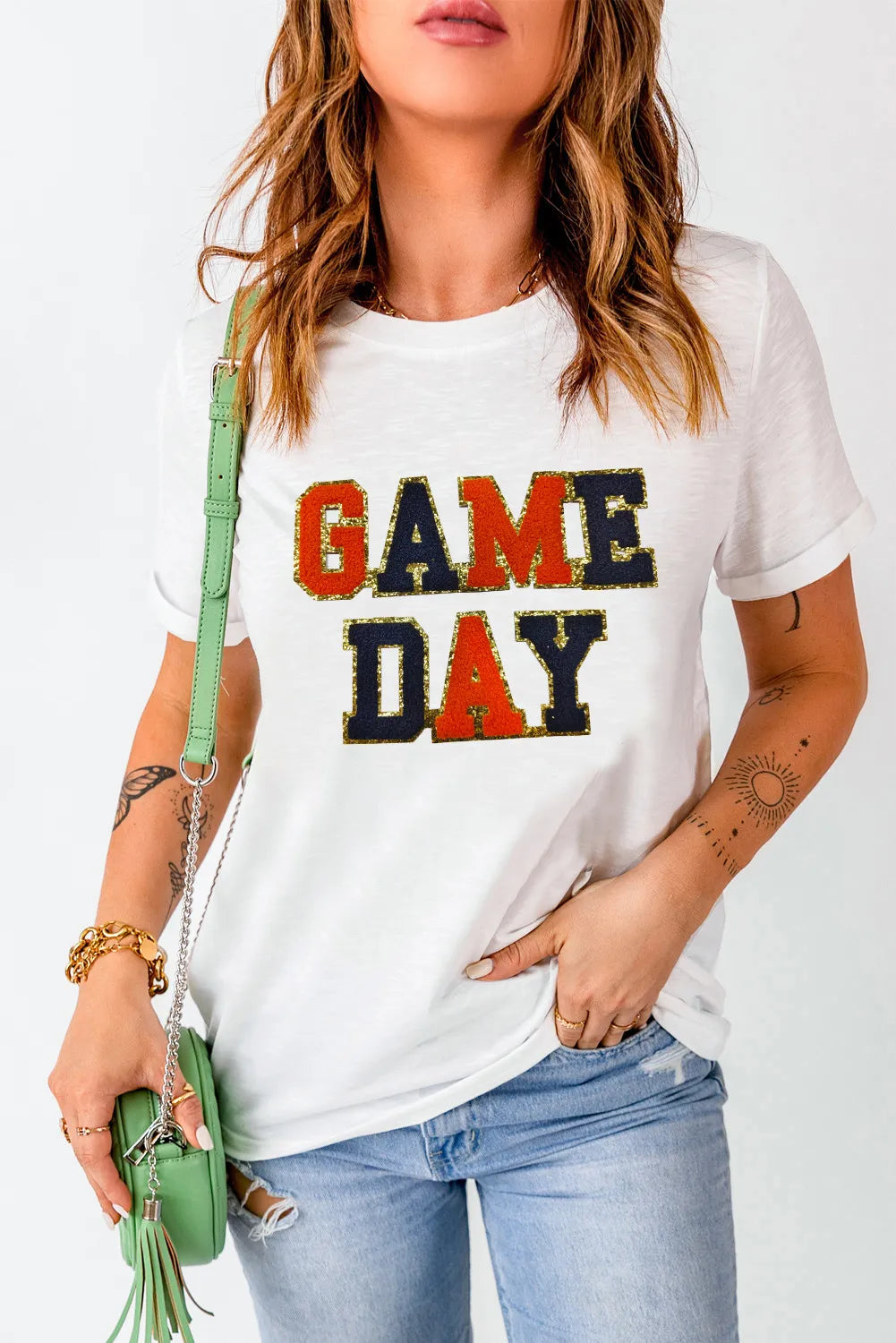 White graphic tee with sequin-trimmed GAME DAY text and rolled sleeves.