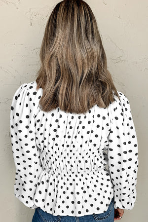 White polka dot blouse with smocked waist and puff sleeves.
