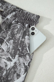 Maple leaf print elastic waist shorts with a phone in the pocket.