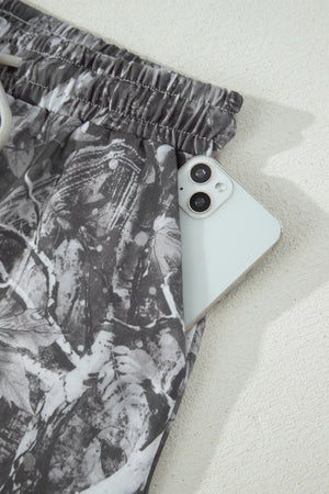 Maple leaf print elastic waist shorts with a phone in the pocket.