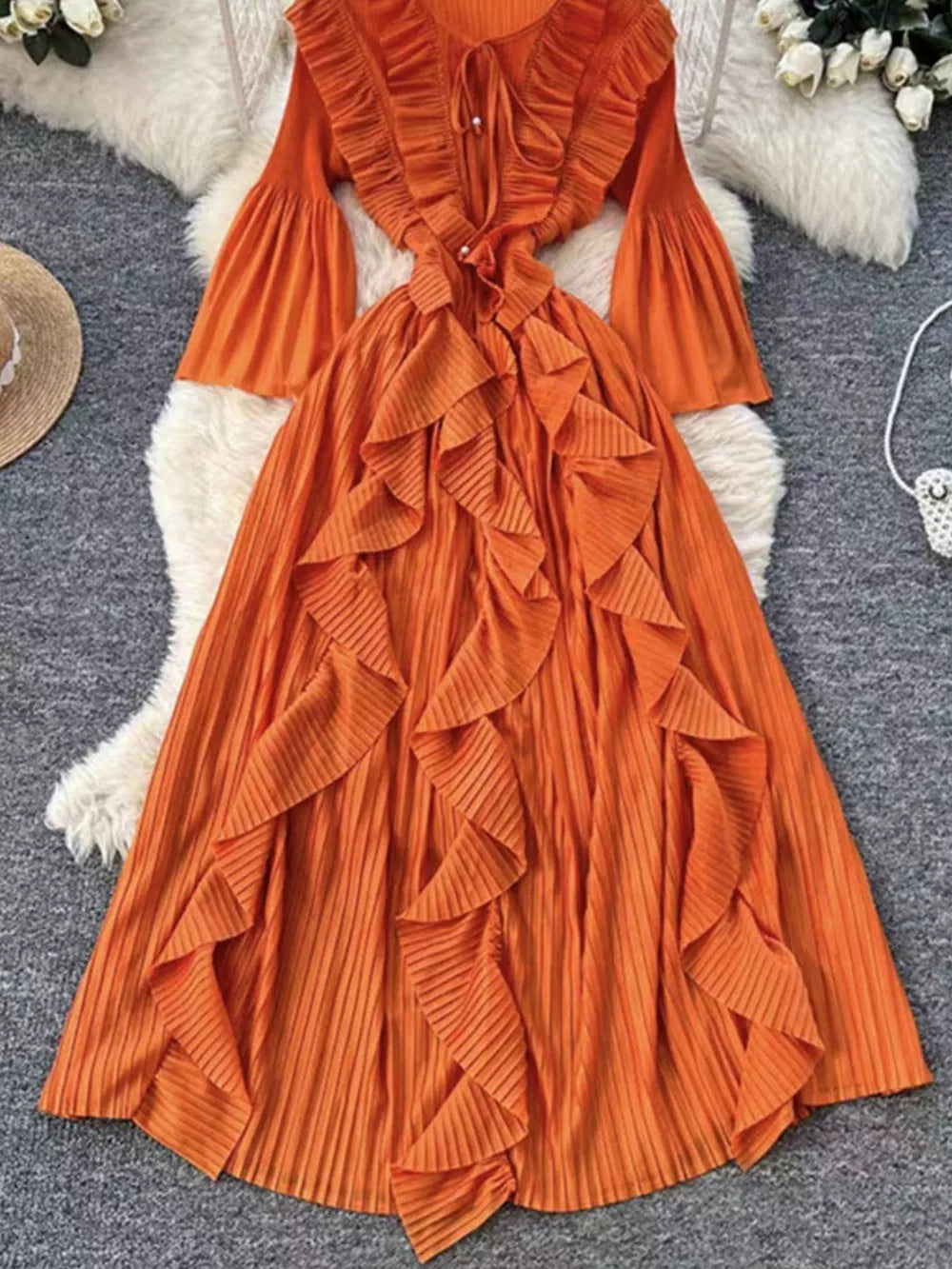 Orange A-line midi dress with cascading ruffles, bell sleeves, and tie neck.