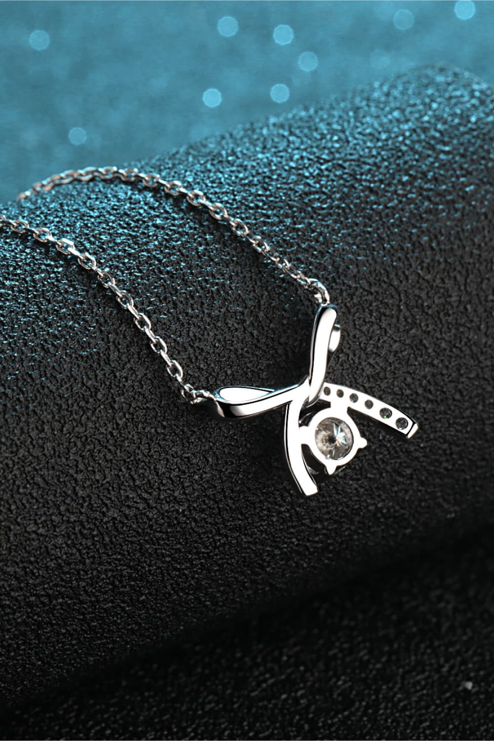 Silver bow-tie diamond pendant necklace with a delicate chain.