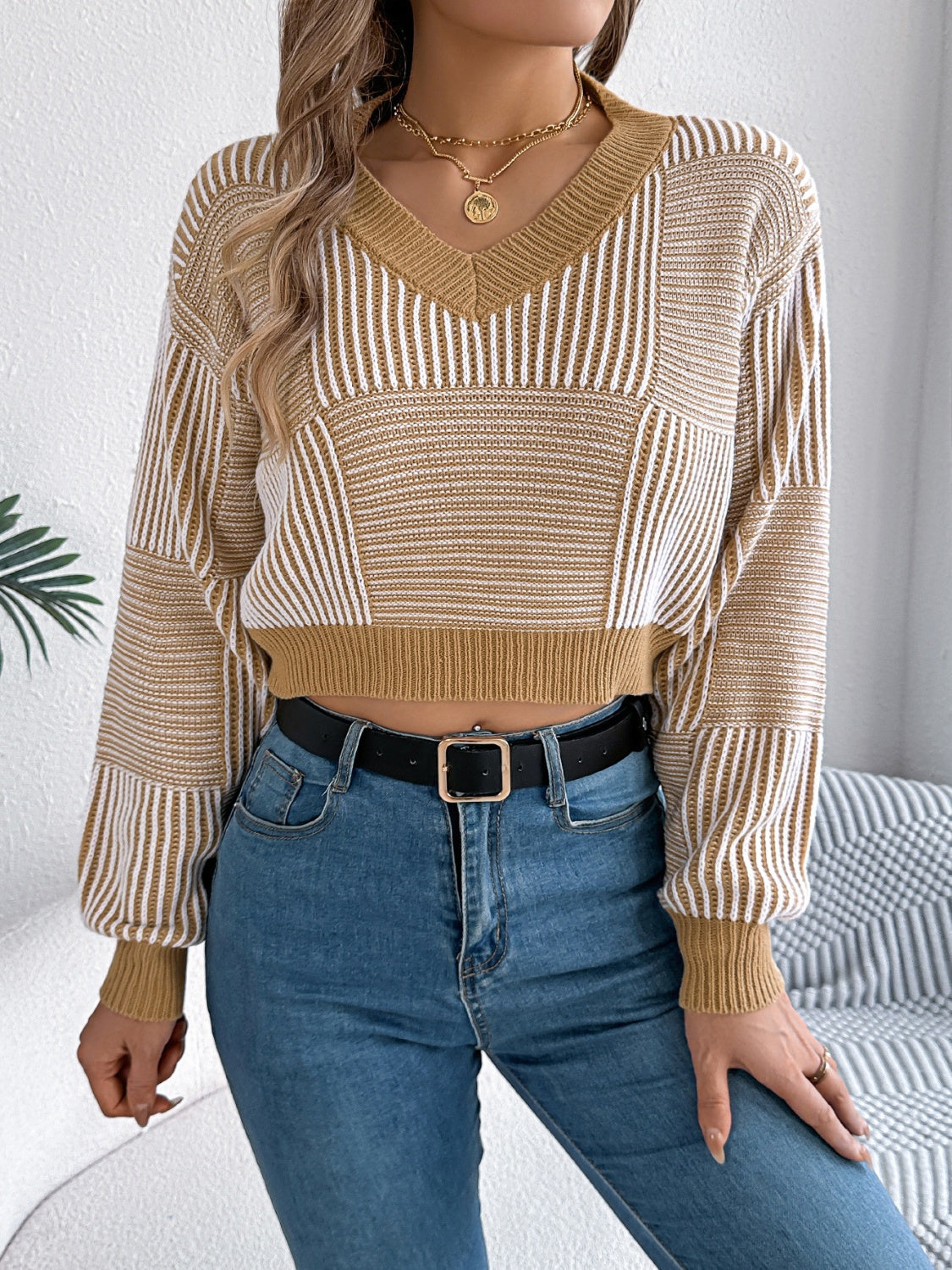 Geometric stripe knit cropped sweater in tan with V-neck and long sleeves.