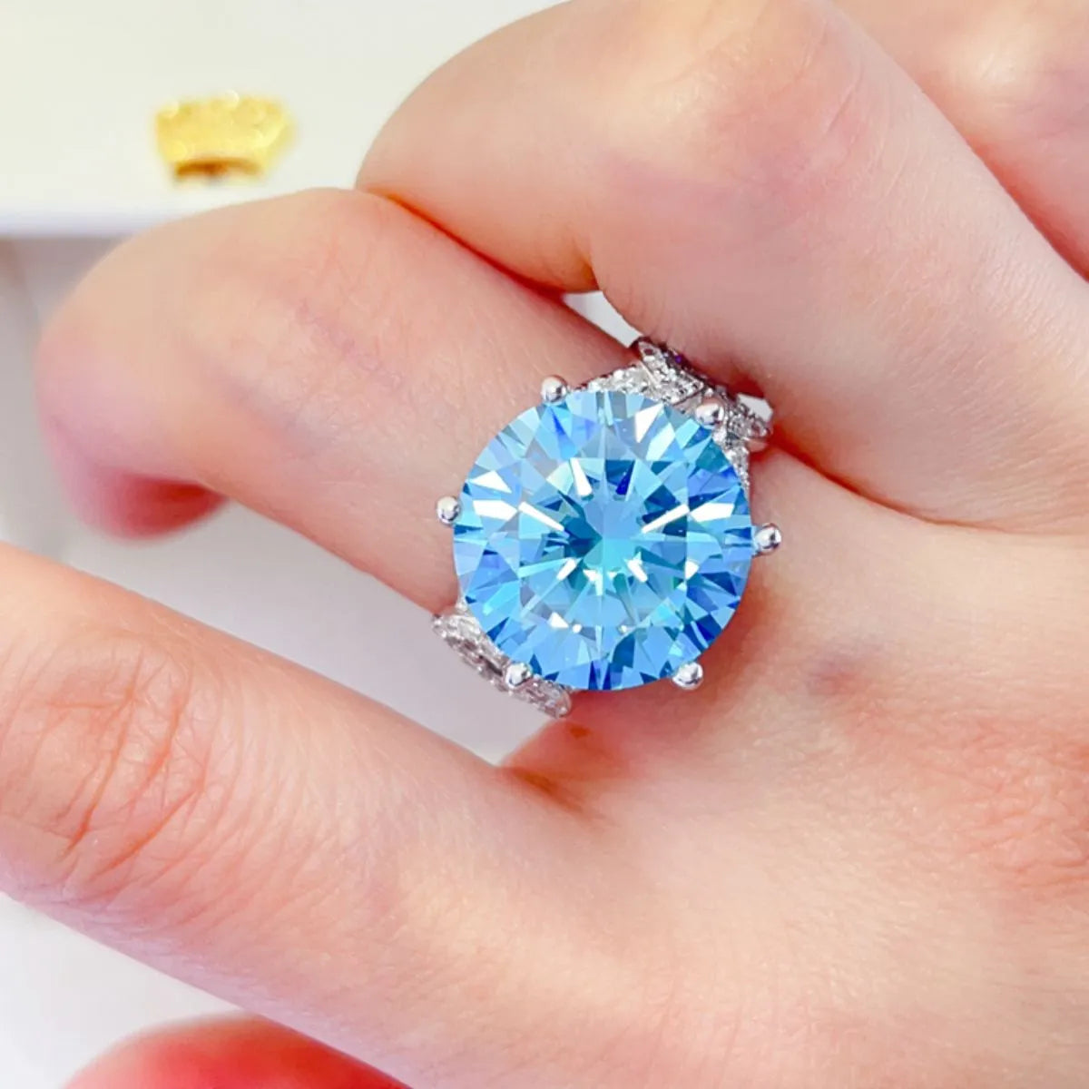 Pastel blue moissanite knot ring with a large round blue stone and diamond accents.
