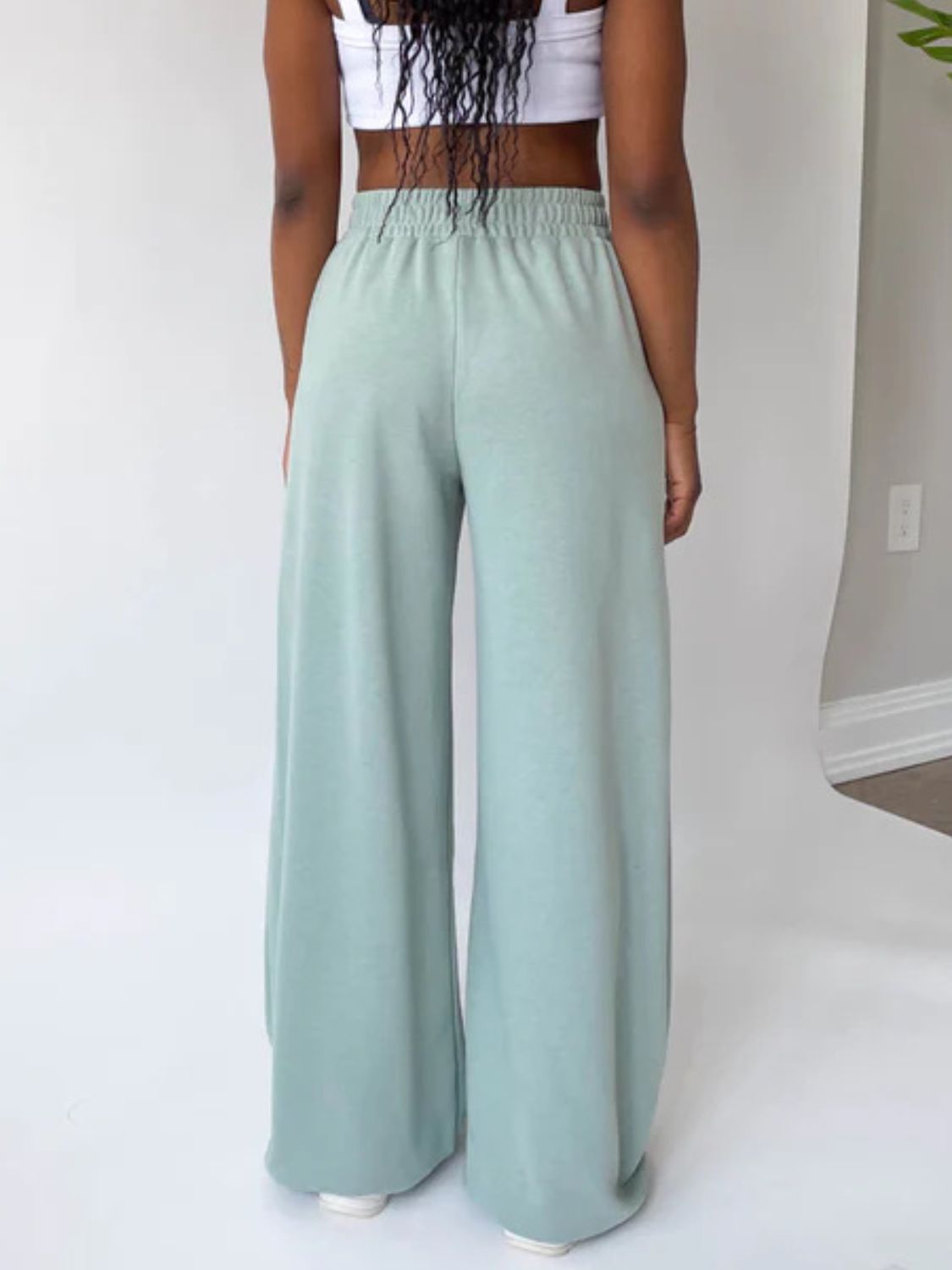 Wide-leg lounge pants in light green with a comfortable elastic waistband.