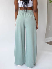 Wide-leg lounge pants in light green with a comfortable elastic waistband.