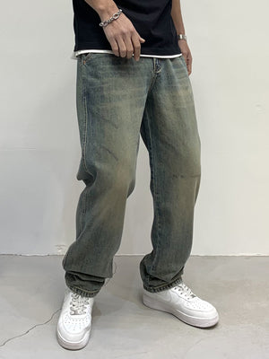 Men's loose-fit jeans in blue-green wash with distressed details and a relaxed cut.