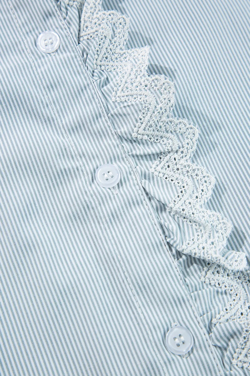 Pinstripe blouse with ruffled lace collar detail and white buttons.
