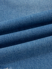 Blue denim fabric detail of high-waisted cuffed barrel jeans