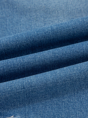 Blue denim fabric detail of high-waisted cuffed barrel jeans