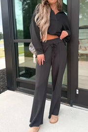 Black collared V-neck sweatshirt and drawstring pants set with a relaxed fit.