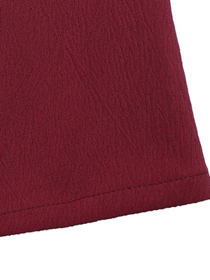 Burgundy textured fabric detail of a romper with a bow-knot detail and spaghetti straps.