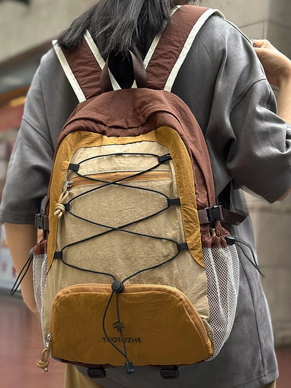 Earthy toned lightweight nylon hiking backpack with bungee cords and mesh pockets.