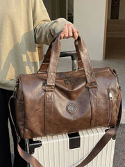 Brown pu leather duffel bag with zippered pockets and top handles.