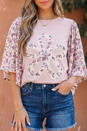 Pink cotton crew neck maternity shirt with floral patchwork sleeves and applique flower detail.