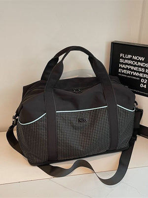Black nylon duffel bag with grid pattern, light blue trim, and detachable strap.