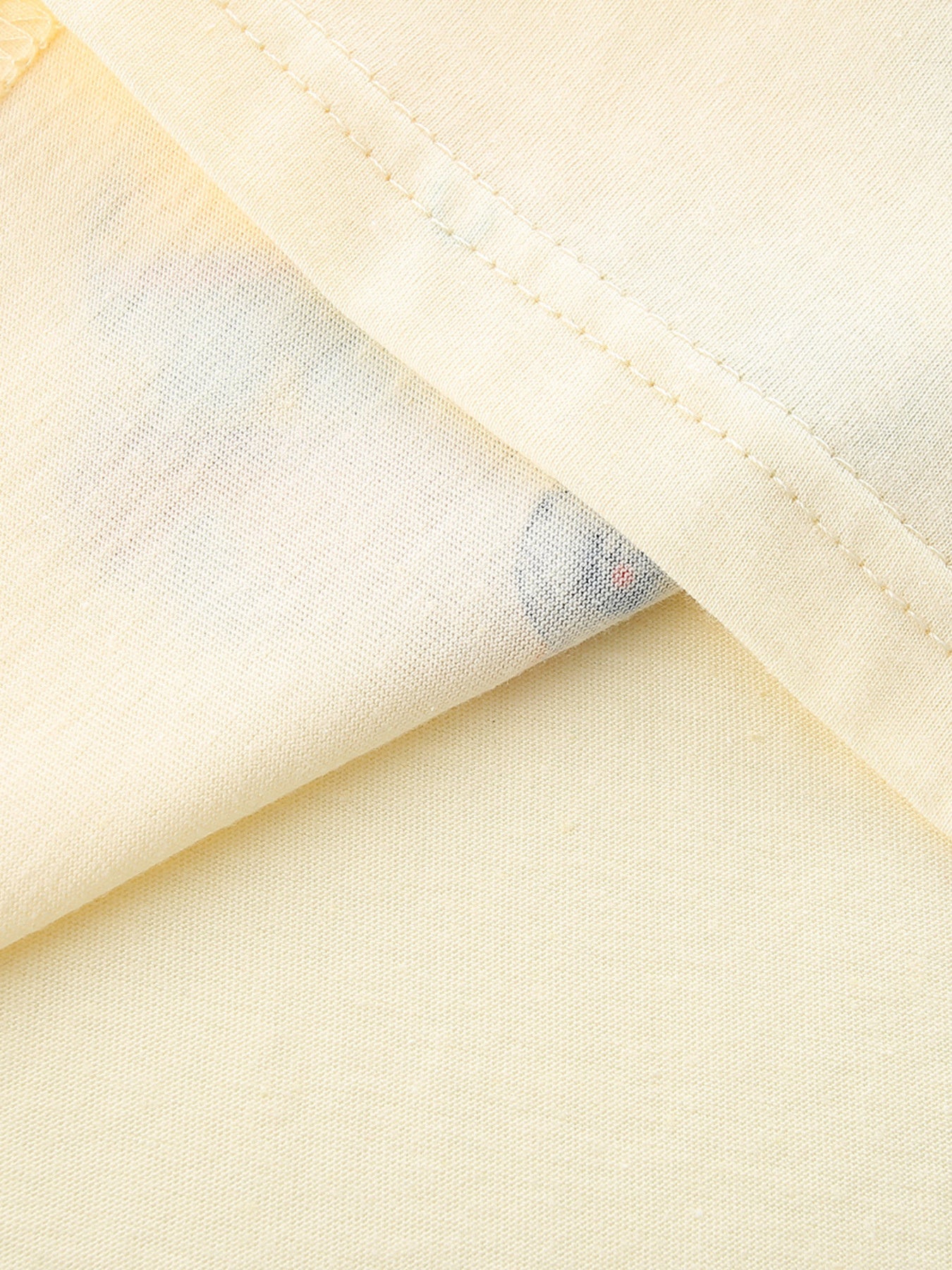 Toddler cream cotton t-shirt with a peek of colorful vehicle print.