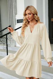 Cream textured babydoll mini dress with voluminous sleeves and tiered hem