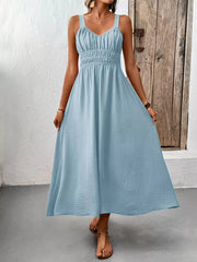 Light blue V-neck smocked midi dress with a textured fabric and spaghetti straps.