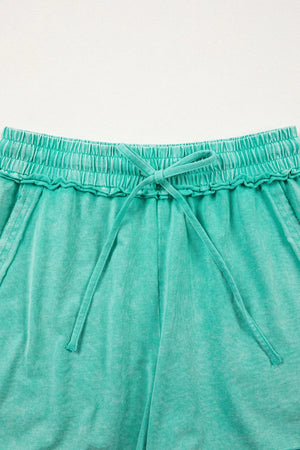 Mineral washed drawstring waist shorts in teal with ruffled elastic waistband and tie.