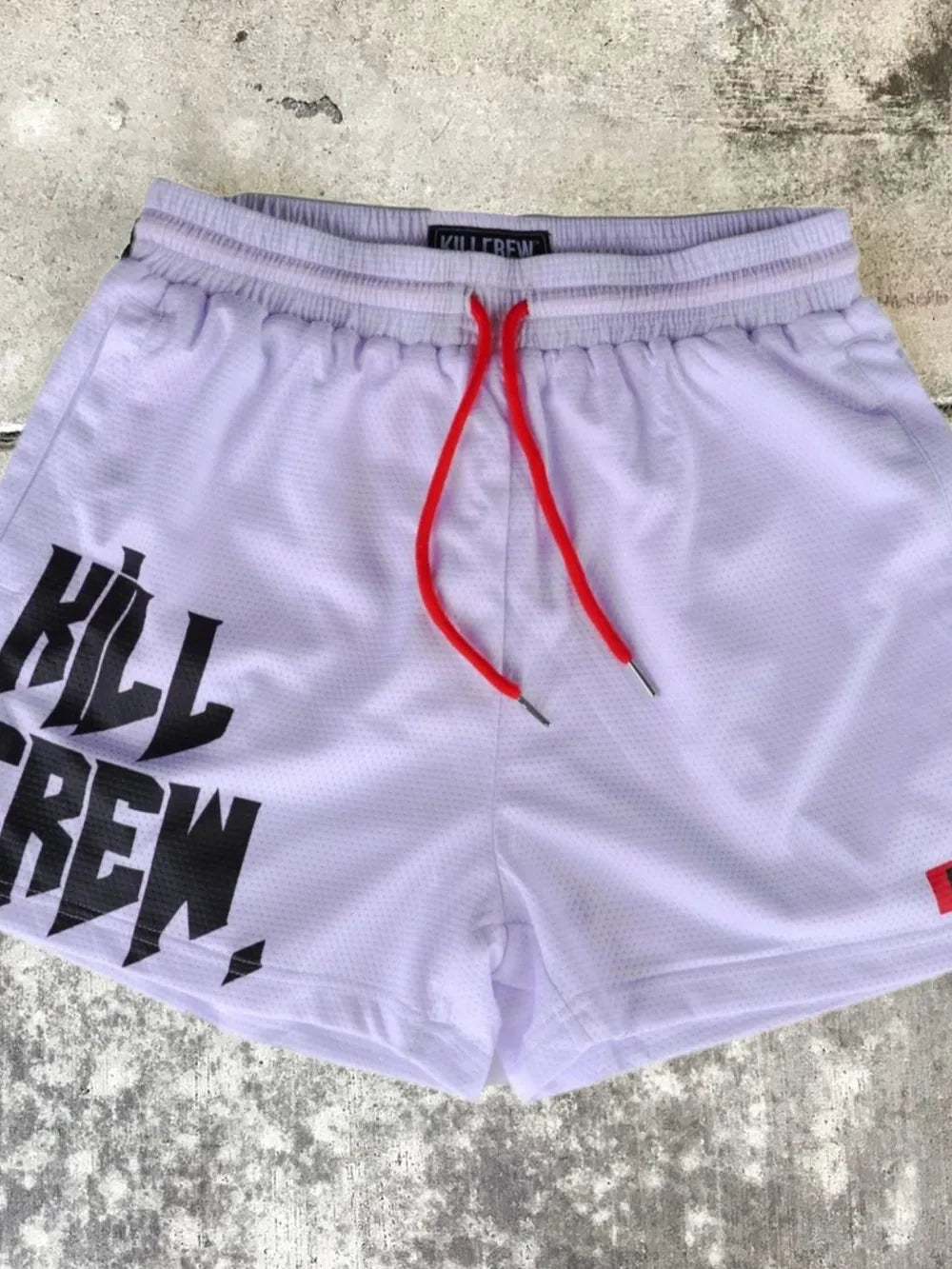 Kill Crew graphic training shorts in white mesh with red drawstrings.