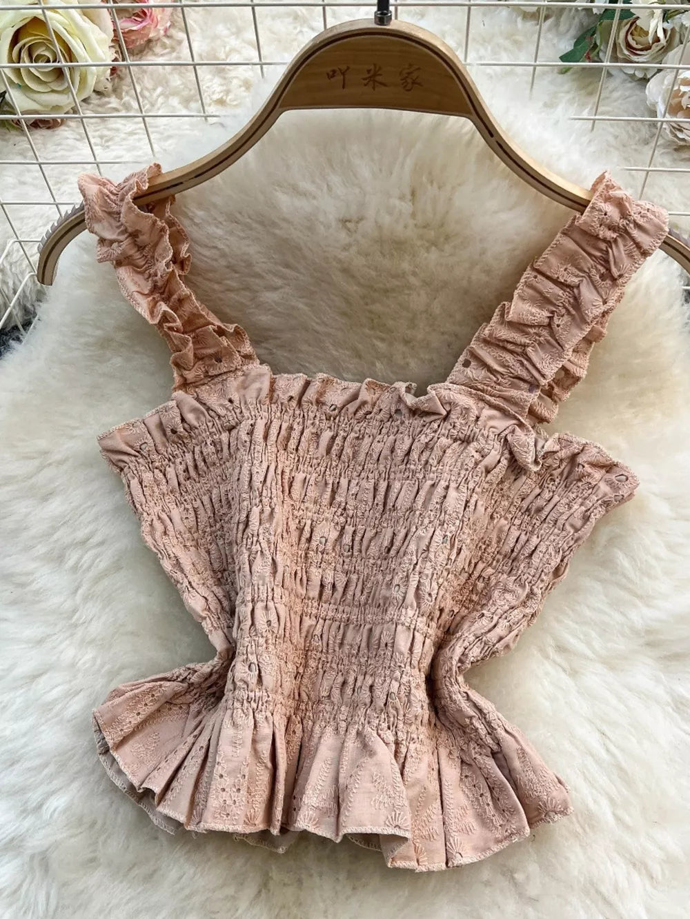 Pink ruffled crop top with smocked bodice and eyelet trim detail