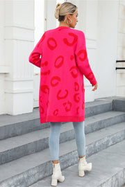 Hot pink knit cardigan with red leopard motif, long sleeves, and pockets.