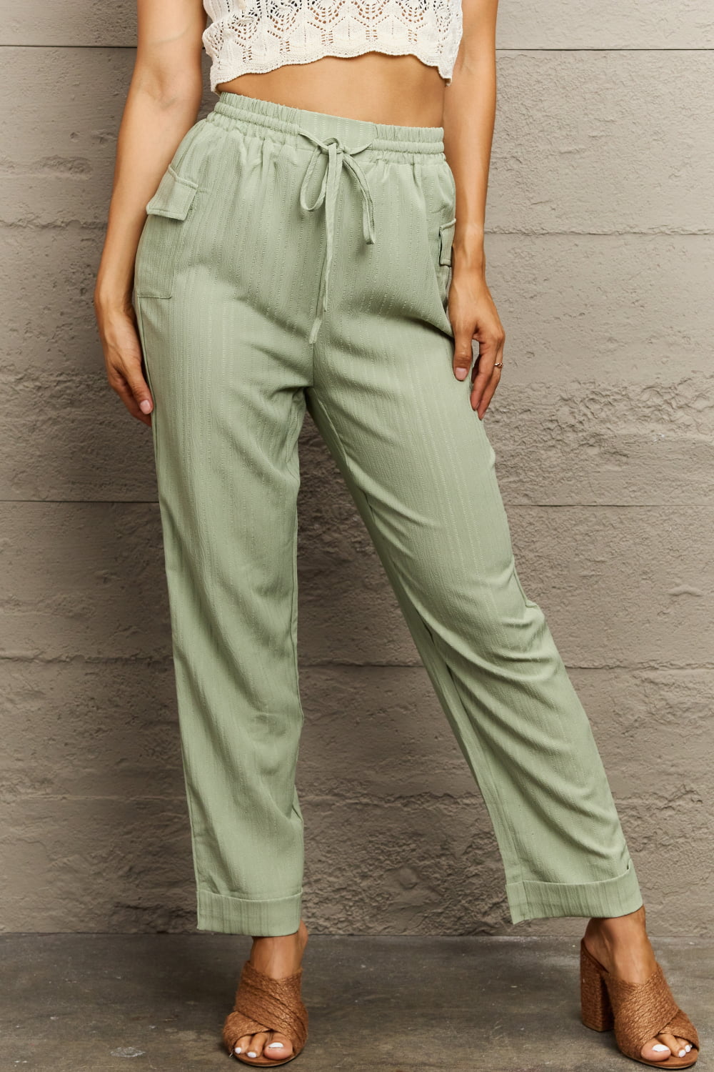Light green utility drawstring cargo pants with textured fabric and side pockets.