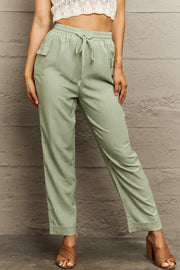 Light green utility drawstring cargo pants with textured fabric and side pockets.
