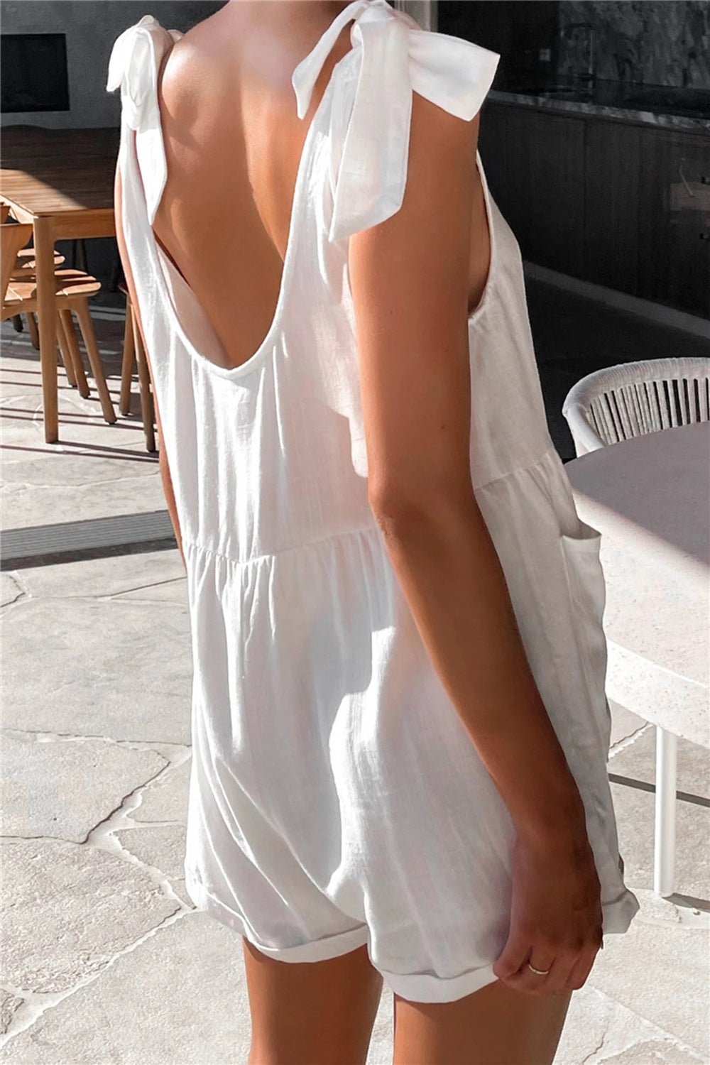 White romper with bow shoulder straps and gathered waist
