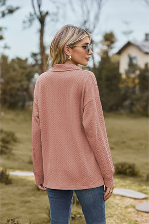 Textured cable knit polo top in dusty pink with a collared neckline and long sleeves.