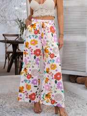 Geometric print wide-leg trousers with drawstring waist and pockets, multicolor floral pattern on light background.
