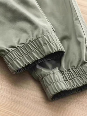 Men's green drawstring joggers with elastic cuffs and relaxed fit.