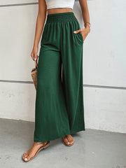 Textured palazzo lounge trousers in dark green with smocked waist and wide legs.
